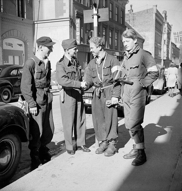 Squadron Leader J Macadam meets three Norwegian resistance fighters in Oslo following the arrival of British forces in Norway, 11 May 1945