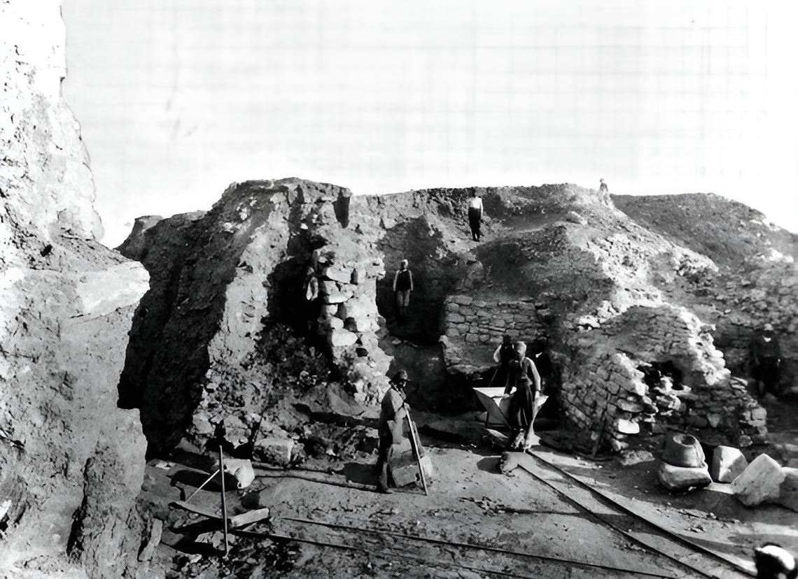 Photo of the summer excavations at Troy in 1890. The dry masonry of ancient structures and hand-pushed trolleys for transporting spoil on a narrow-gauge railway are clearly visible