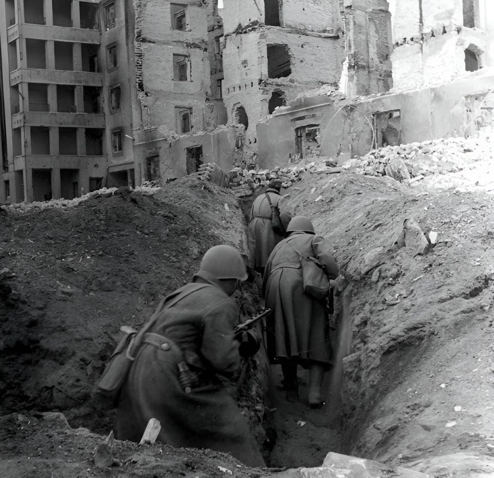 Soviet soldiers running through trenches in the ruins of Stalingrad