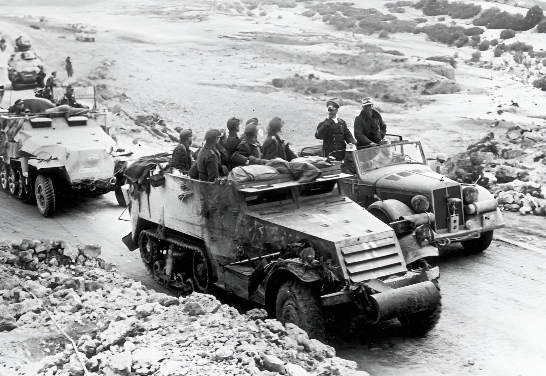 Rommel speaks with troops who are using a captured American M3 half-track, Tunisia